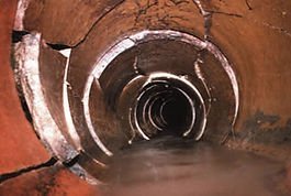 Camera view inside an old clay drain pipe with cracks and a displaced joint
